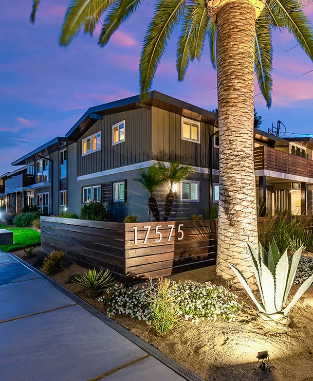 Palm View Village apartment building at 17575 Yukon Avenue beneath palm trees at dusk