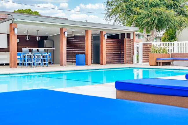 Palm View Village swimming pool beside a covered outdoor kitchen and seating area